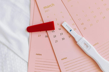 Pregnancy test kit in a box with baby shoes